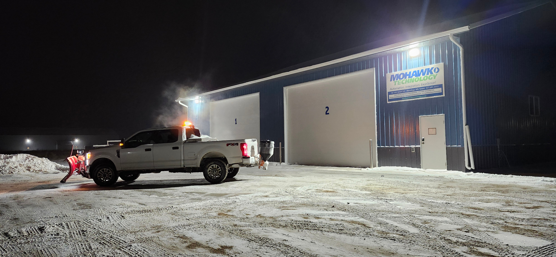 Plow truck clearing a commercial building lot